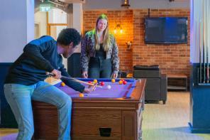 Two students playing pool in the LMH Bar