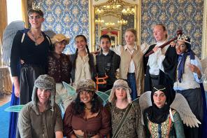 A photo of a group of students dressed in costumes to perform a play in a historic house