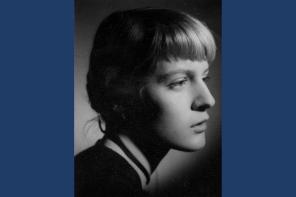 A black and white portrait photo of a young woman with tied-back blonde hair and a fringe