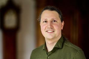 Photo of Dr Balint Koczor, who has long hair pulled back in a ponytail