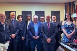 A photo of a group of people standing in a music recording studio in Lady Margaret Hall