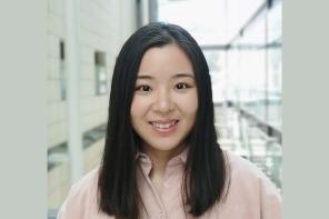 Yujia Qing standing in a brightly lit atrium
