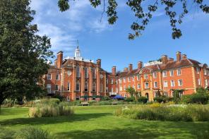 Photo of LMH's red brick buildings taken from within the gardens