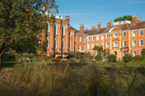 LMH's red brick buildings sitting amongst deep green trees and planting