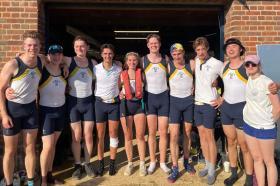 A group of students standing in the sunshine outside of the LMH boathouse