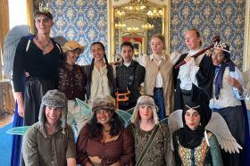 A photo of a group of students dressed in costumes to perform a play in a historic house