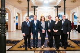 A group of six men and women dressed in smart suits and standing in the lobby of the National Philharmonic of Ukraine in Kyiv