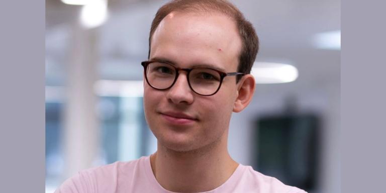 Photo of David Geldbach, who wears glasses and pink tshirt