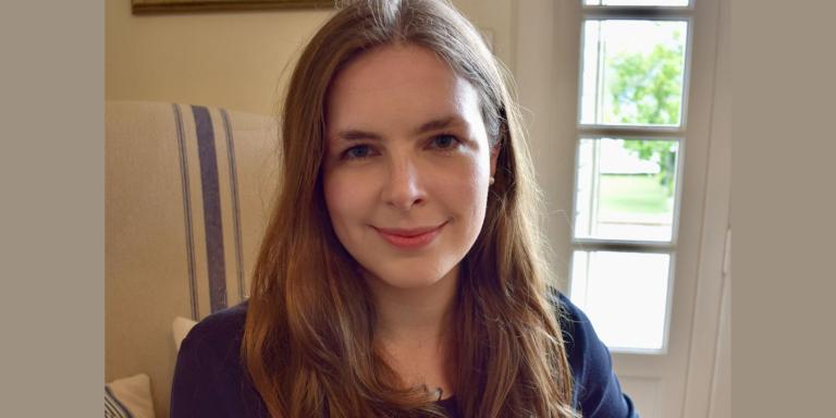 Grace Mallon, who has long brown hair, smiling at the camera