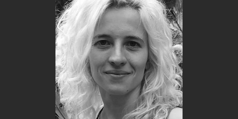A black and white portrait photo of a woman with bleached blonde wavy hair