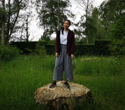 Photo of a woman standing on a bale of hay
