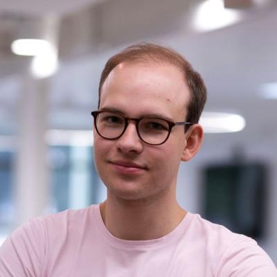 Photo of David Geldbach, who wears glasses and pink tshirt