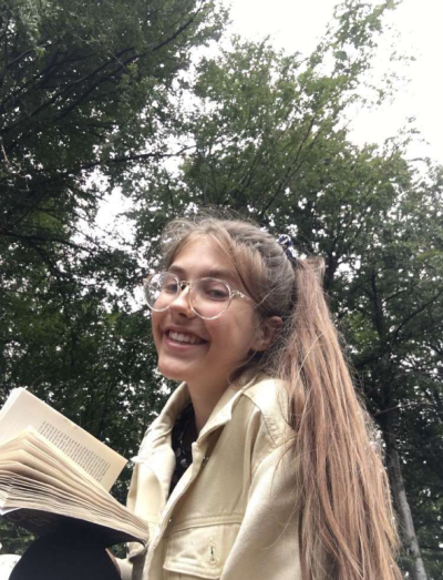 Photo of Grace Critchley reading a book outdoors