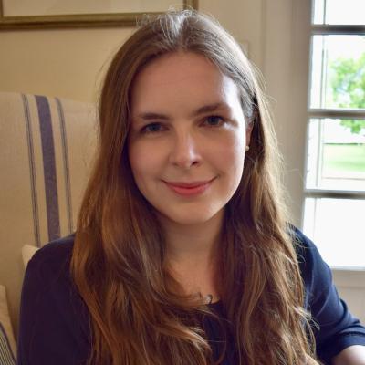 Grace Mallon, who has long brown hair, smiling at the camera