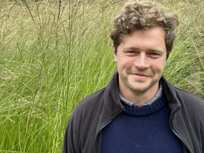 A photo of Oakley Loudon standing in front of LMH's grass garden